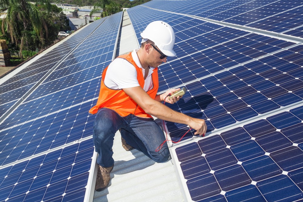 Solar technician inspecting roof panels