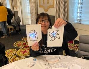 Teacher holding up lit pieces of paper with LEDS